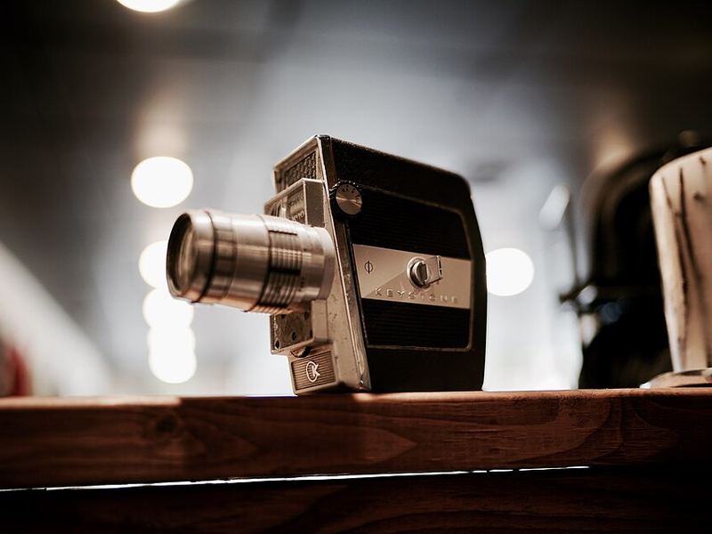 A vintage movie camera on a wooden shelf