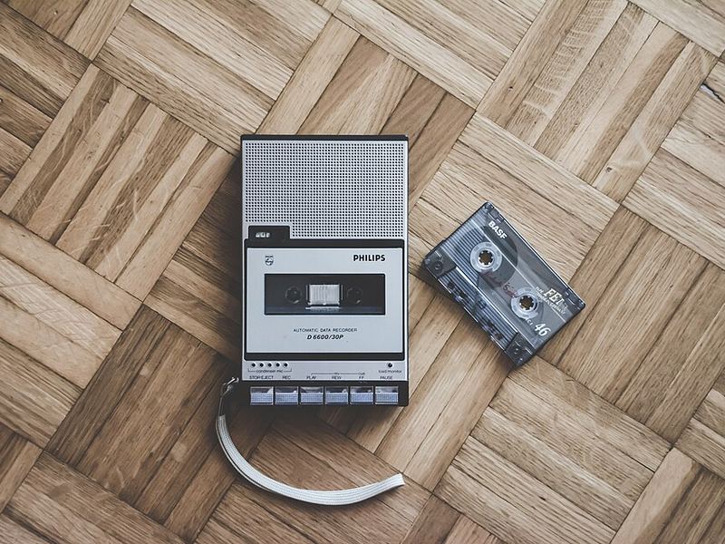 A Philips portable cassette recorder and a cassette tape on a parquet floor