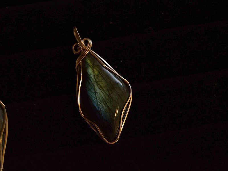 A wire-wrapped stone pendant on a dark background