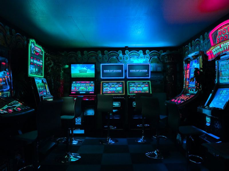 A room of arcade machines lit in neon colors