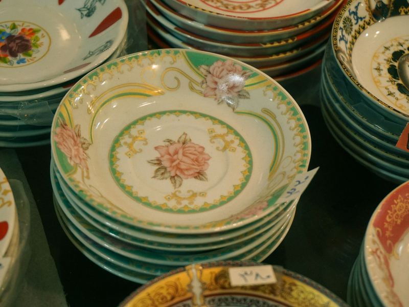 Stacks of vintage hand-painted china bowls and plates with floral patterns