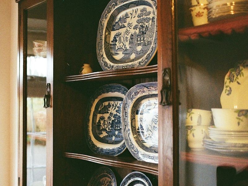 Blue and white plates and dishes displayed in an antique wooden china cabinet